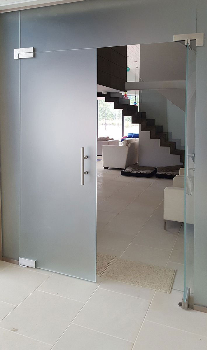 frameless glass partition with hinged doors and privacy glass